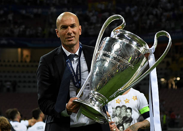 real-madrid-head-coach-zinedine-zidane-shows-the-trophy-after-winning-picture-id535011666